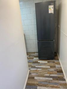 a refrigerator in a hallway with a tile floor at ROTUNDO APART in Puerto Natales