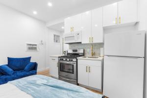 a white kitchen with a stove and a blue couch at 316 Footloose #1 in Hollywood