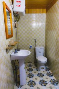 a bathroom with a white toilet and a sink at The Link farmstay in Sa Pả