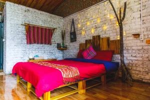 a bedroom with a large bed with a red blanket at The Link farmstay in Sa Pả