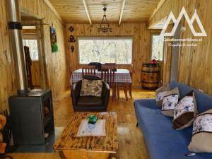 a living room with a blue couch and a stove at Mont blanc II in Las Trancas
