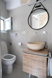 bagno con lavandino, servizi igienici e specchio di Adelmarì Casa Vacanze a Manfredonia