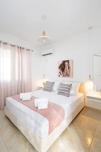 um quarto branco com uma cama grande e 2 almofadas em K&D Central Suite em Sitia
