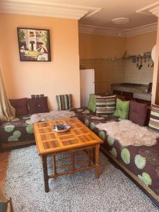 een woonkamer met een bank en een tafel bij Vu sur corniche in Safi