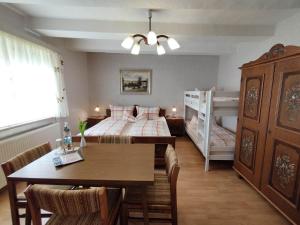 a bedroom with a bed and a table and a bunk bed at Pension Hoffmann in Trebra