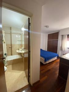 a bathroom with a bedroom with a bed and a shower at Departamento 2 dormitorios frente Patio Olmos Nva Cba ubicación ideal in Córdoba