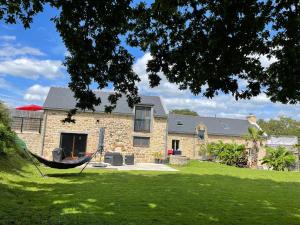 a stone house with a hammock in front of it at Gîtes d Izel N1 entre terre et mer prés d'un golf in Ploemel