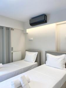 two beds in a room with a tv on the ceiling at Cottage Boutique Apartments Athens in Athens