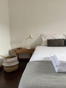 1 dormitorio con 1 cama y 1 mesa con lámpara en Casa da Pedrada, en Ponte da Barca