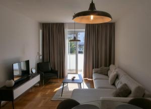 a living room with a couch and a tv at Apartments Radovic in Podgorica