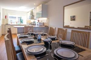 a dining room table with plates and wine glasses at Clearwater 28, Wild Briar - P in Somerford Keynes