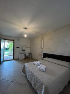 una camera da letto con un letto e due asciugamani di Masseria Tumara Rooms and Apartments a Otranto
