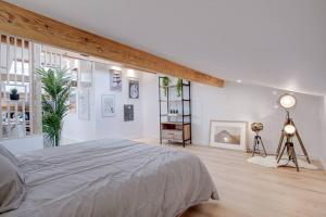 um quarto branco com uma cama e uma grande janela em Le Saint-éxupery em Toulouse