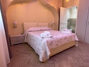 1 dormitorio con 1 cama con colcha rosa en Casa Vacanze Prezioso, en Bisacquino