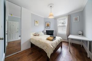 a small bedroom with a bed and a desk at Royal Greenwich Hospitality in London