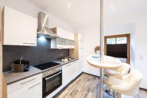 a kitchen with white cabinets and a small table at Ferienwohnung Annemarie in Mieders