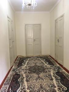 una habitación vacía con dos puertas y una alfombra en Welcome Guest House, en Tokmok