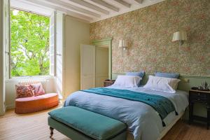 ein Schlafzimmer mit einem großen Bett und einem Fenster in der Unterkunft Maison d'hôtes et gîte en Sarthe in Saint-Christophe-en-Champagne