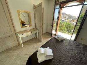 1 dormitorio con espejo y 1 cama con toallas en Casa Vacanze Prezioso, en Bisacquino