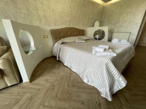 een slaapkamer met een bed met witte lakens en een houten vloer bij Casa Vacanze Prezioso in Bisacquino