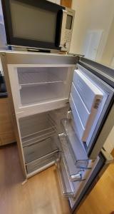 an empty refrigerator with its door open in a kitchen at Apartmán Husovka Bruntál - pokoj POLLY in Bruntál