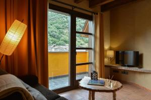 a living room with a large window and a table at La Rectoria in Vall de Castellbò