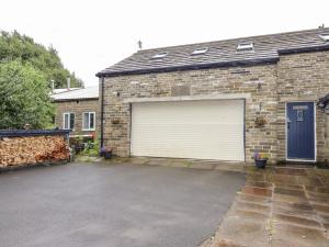 a brick house with a garage with a door at Ash Tree Barn in Clayton