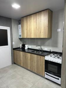 een keuken met houten kasten en een fornuis met oven bij Casa Valentino in Rafaela