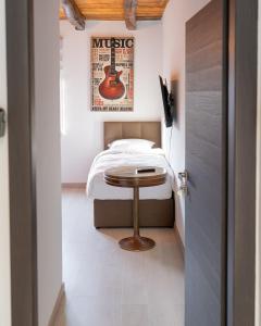 a bedroom with a bed with a guitar on the wall at Arena Rooms Zagreb in Zagreb