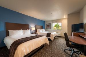 a hotel room with two beds and a desk and a tv at My Place Hotel-Colorado Springs,CO in Colorado Springs