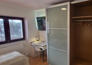 a bedroom with a desk and a glass shower door at Apartmán Husovka Bruntál - pokoj POLLY in Bruntál