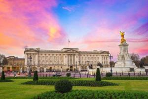 a large building with a statue in front of it at Modern Buckingham Palace Apartment in London
