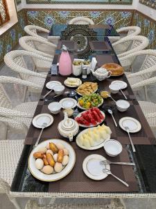 a long table with plates of food on it at Hotel Khalid in Bukhara