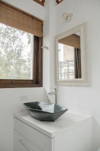 bagno con lavandino nero e specchio di Casa Dino en Villa de Leyva a Villa de Leyva