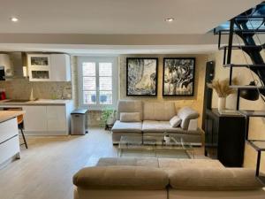 a living room with a couch and a kitchen at Superbe duplex, Centre historique, 5 personnes in Bellême