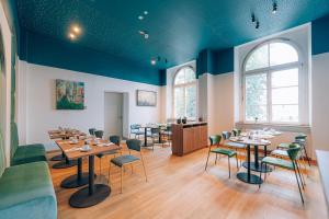 a dining room with tables and chairs and blue ceilings at Hotel Amalia - Boutique Hotel in Landshut