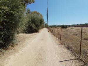 eine unbefestigte Straße mit einem Zaun an der Seite in der Unterkunft CostasFarmhouse, Pallini, Near Athens Airport in Pévka