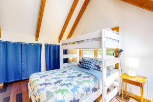 een slaapkamer met een stapelbed en blauwe gordijnen bij Cabin in the Woods in Owls Head