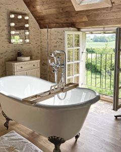 un bagno con ampia vasca e finestra di Maison d'hôtes et gîte en Sarthe a Saint-Christophe-en-Champagne