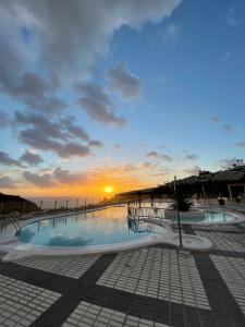 una piscina con il tramonto sullo sfondo di Ocean view a Puerto Rico de Gran Canaria