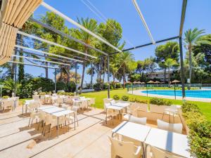 een terras met tafels en stoelen en een zwembad bij Cubo's Torre Andalucia Marbella Apartment in Marbella