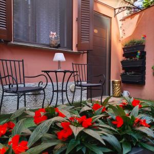 a patio with red flowers and a table and chairs at Casa Varenne in Stropino