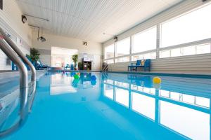 a large indoor swimming pool with blue water at Crosswinds Inn in West Yellowstone