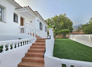 une maison blanche avec des escaliers et une cour verdoyante dans l'établissement Luxury villa city Centre, à Marbella