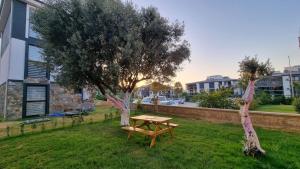 a picnic table in the grass next to a tree at Villa Begonvil in Kusadası