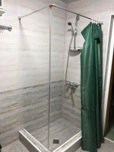 a shower with a glass door in a bathroom at House of greenery in Kutaisi