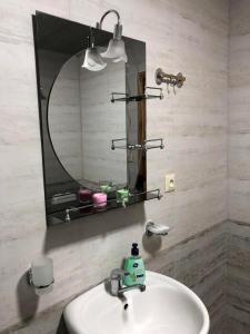 a bathroom with a sink and a mirror at House of greenery in Kutaisi