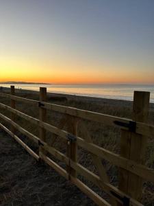 a wooden fence on the beach at sunset at Tiny house - Playa in Arauco