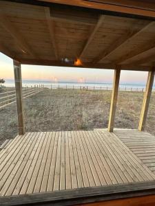 une terrasse couverte d'une maison avec vue sur la plage dans l'établissement Tiny house - Playa, à Arauco