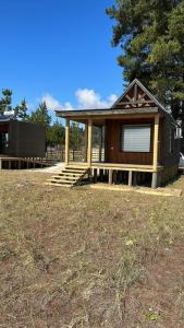 a small cabin with a porch in a field at Tiny house - Playa in Arauco